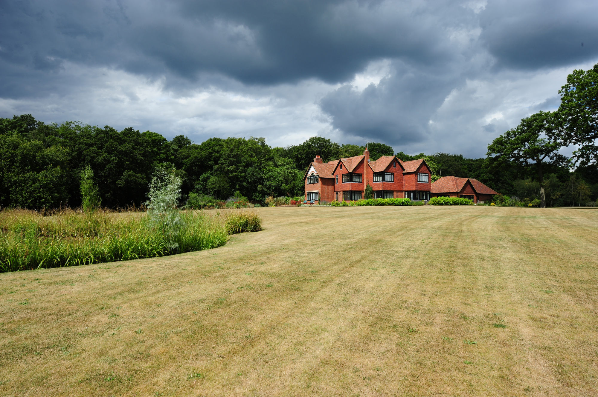 Brick house and lawn under a stormy sky